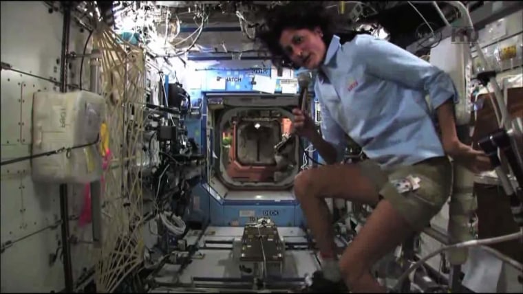 NASA astronaut Sunita Williams demonstrates how to use the International Space Station's exercise bike during an interview with CNN. Williams is training to participate in the Nautica Malibu Triathlon from orbit.