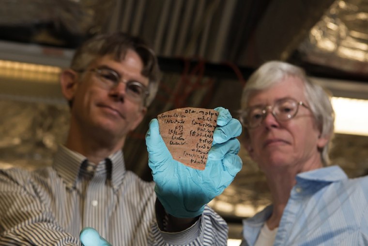 Brian Muhs and Janet Johnson, researchers at the University of Chicago's Oriental Institute, display a pottery piece with Demotic writing.