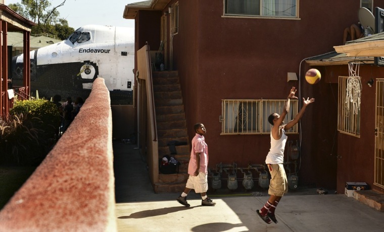 Image: Traymond Harris and Ryan Hudge play basketball as Space Shuttle Endeavour travels to the California Science Center on Crenshaw Ave in Inglewood, Los Angeles