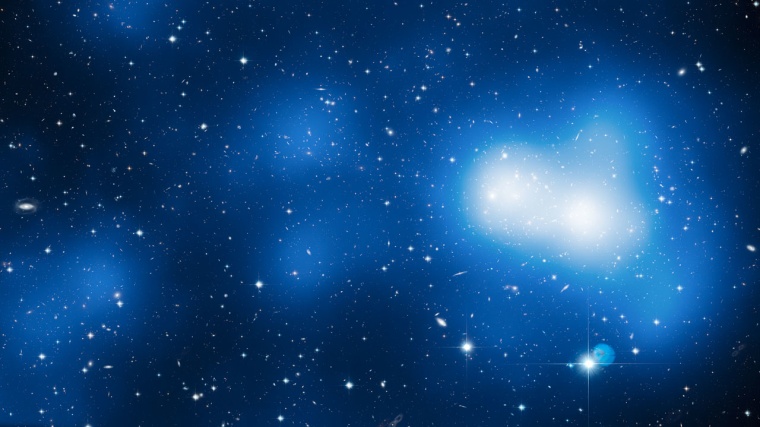 This enormous image shows Hubble’s view of massive galaxy cluster MACS J0717. The large field of view is a combination of 18 separate Hubble images. The location of the dark matter is revealed in a map of the mass in the cluster and surrounding region, shown here in blue. The filament visibly extends out and to the left of the cluster core.