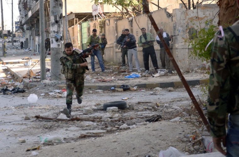 Image: Syrian government forces run for cover during clashes with rebel fighters in Maysalun neighbourhood of Aleppo,