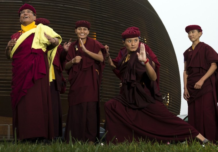 Image: The 12th Gyalwang Drukpa, Jigme Pema Wangchen, poses with Kung-Fu trained nuns accompanying him at the European Organization for Nuclear Research near Geneva