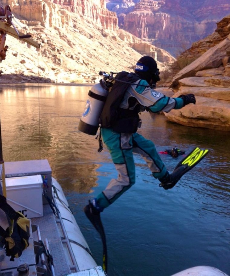 USGS hydrologist Tom Sabol enters the Colorado River in scuba diving gear to sample sediment in preparation for the November flood from the Glen Canyon Dam.