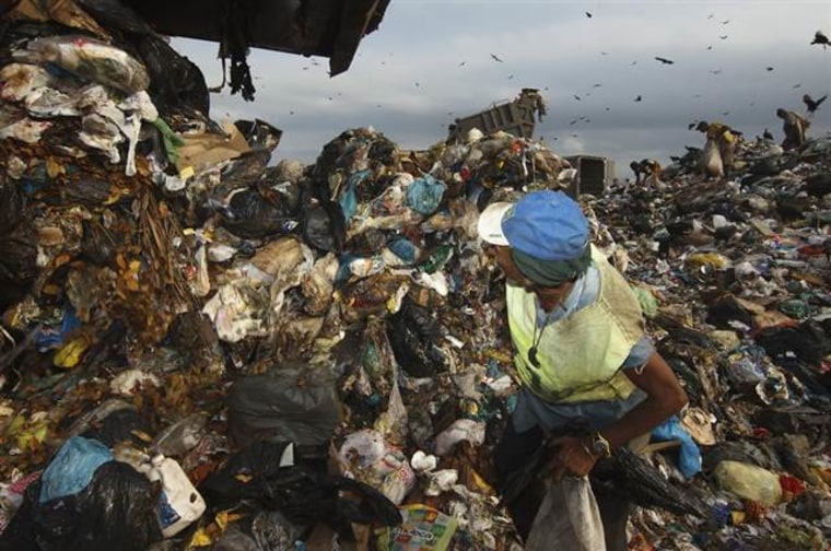 A man works among rubbish at Rio de Janeiro's Jardim Gramacho, the biggest open air garbage dump in Latin America, on June 2 just before it closed for good. It was long a symbol of ill-conceived urban planning and environmental negligence.