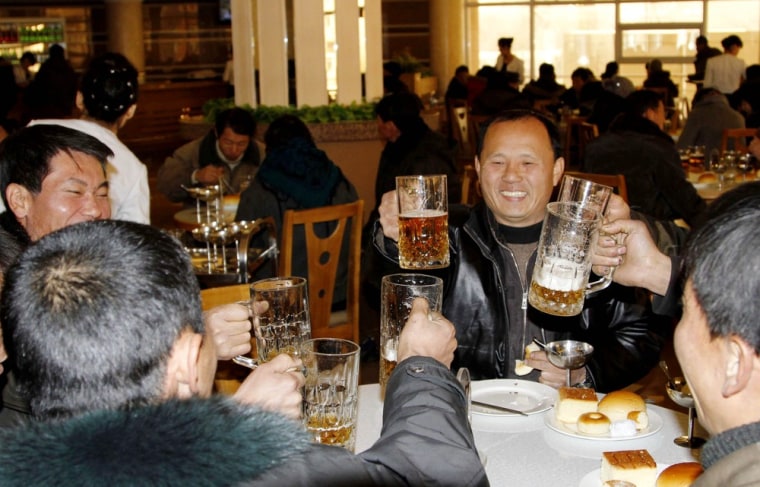 Image: North Koreans toast after hearing the news of a  rocket launch with beer at the newly-built Mansukyo Restaurant.