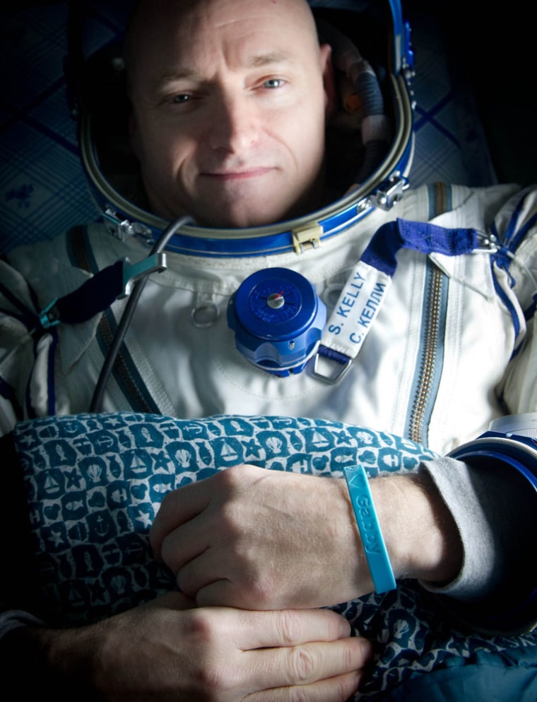 Expedition 26 Commander Scott Kelly wears a blue wrist band that has a peace symbol, a heart and the word \"Gabby\" to show his love of his sister-in-law U.S. Rep. Gabrielle Giffords as he rest onboard a Russian Search and Rescue helicopter shortly after he and fellow crew members Oleg Skripochka and Alexander Kaleri landed in their Soyuz TMA-01M capsule near the town of Arkalyk, Kazakhstan on Wednesday, March 16, 2011.  NASA Astronaut Kelly, Russian Cosmonauts Skripochka and Kaleri are returning from almost six months onboard the International Space Station where they served as members of the Expedition 25 and 26 crews. Photo Credit: (NASA/Bill Ingalls)