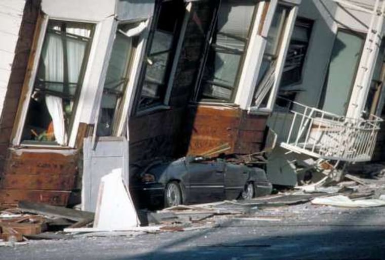 An automobile lies crushed under the third story of this apartment building in the Marina District, California, from the Loma Prieta earthquake in 1989.