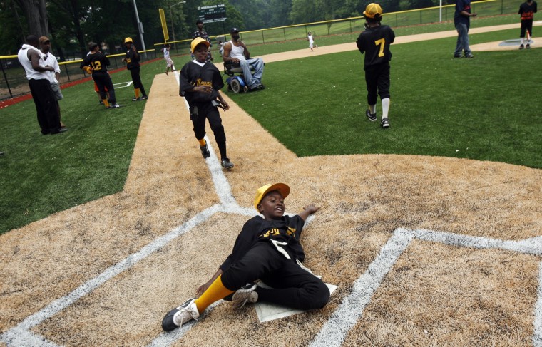 Newark Eagles Little League player Nasir Scott slides into home after a victory lap following the team's win over the Black Yankees at Weequahic Park on June 14, 2008.