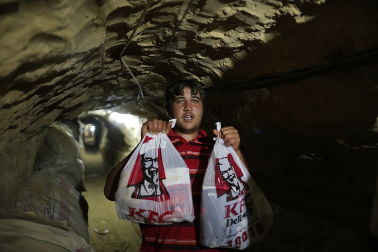 A man holds KFC food in the underground tunnel beneath the Gaza-Egypt border.