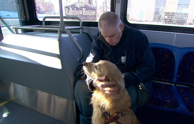 Harold Leigland with his guide dog on the bus during his morning commute to the Goodwill facility in Great Falls, Montana, where he works hanging clothing and earns $5.46 an hour.