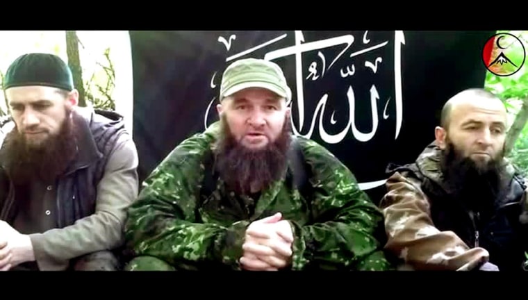 Image: A man identified as Russia's top Islamist leader Doku Umarov, center