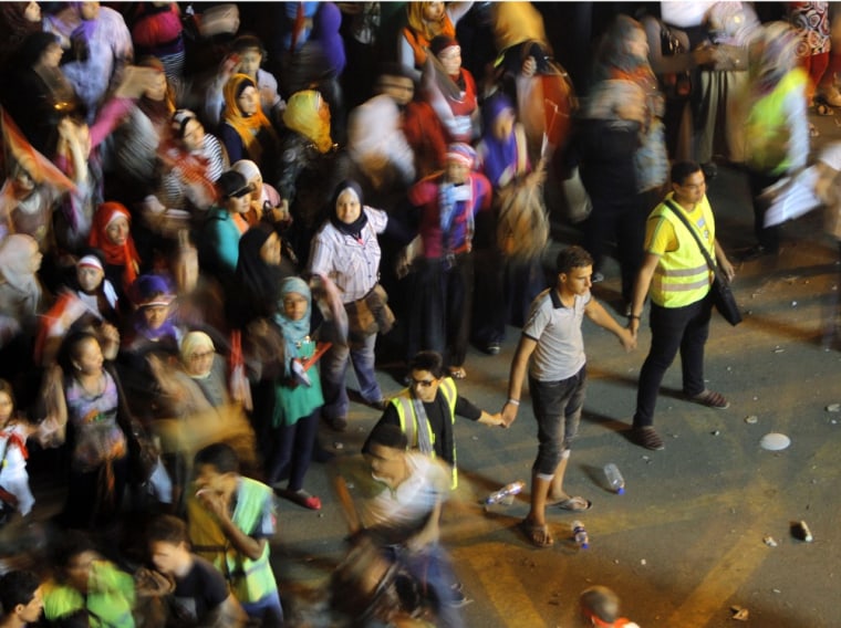 Image: Volunteers secure women opponents of Egypt's ousted president Mohammed Morsi in Tahrir Square.