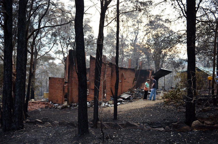 Jennifer Schweinsberg and her son David look at their gutted house in Winmalee in the Blue Mountains on Tuesday.