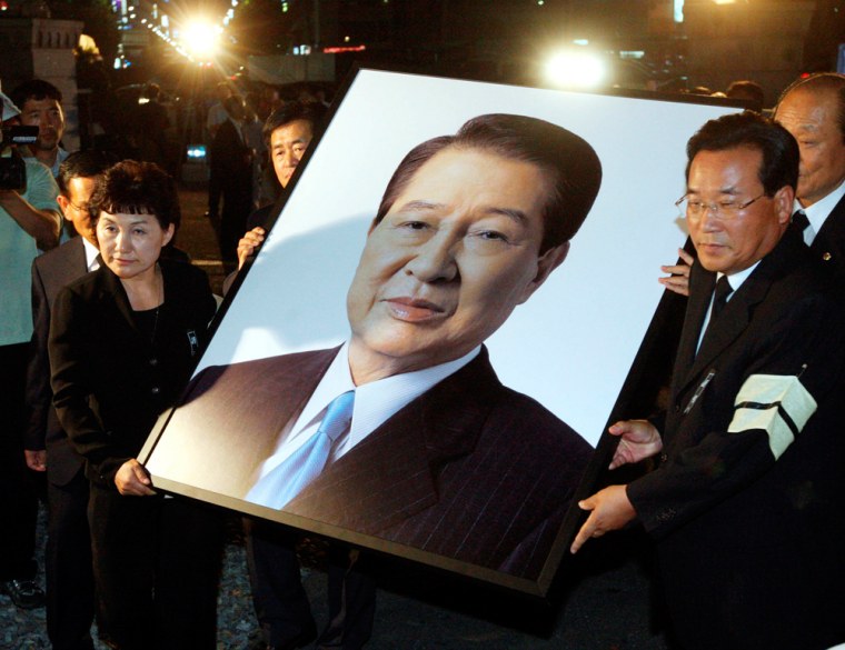 Image: South Koreans carry a portrait of the late former South Korean President Kim Dae-Jung