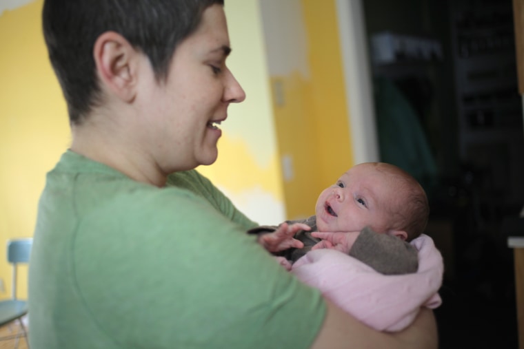 Image: Lisa Bender, who is undergoing treatment for breast cancer, holds her newborn baby daughter Alice in their home in Minneapolis, Minn. on April 1.