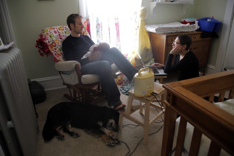 Image:Lisa Bender, who is undergoing treatment for breast cancer, sits in the nursery of her newborn baby daughter, Alice, who is being fed by her husband Ryan, in their home in Minneapolis, Minn. on March 30.