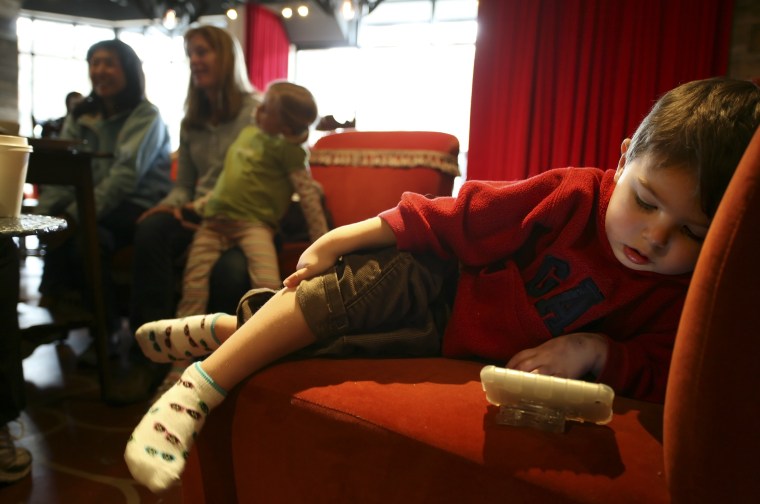 Image: Matthew West, 3, watches a video on his Mom's iPhone while she talks with friends at Starbucks