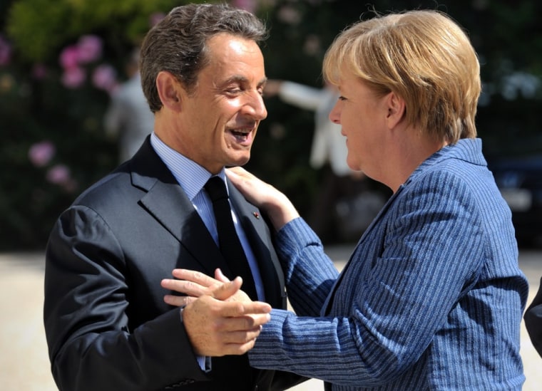 Image: France's President Nicolas Sarkozy welcomes German Chancellor Angela Merkel as she arrives for a meeting at the Elysee Palace in Paris