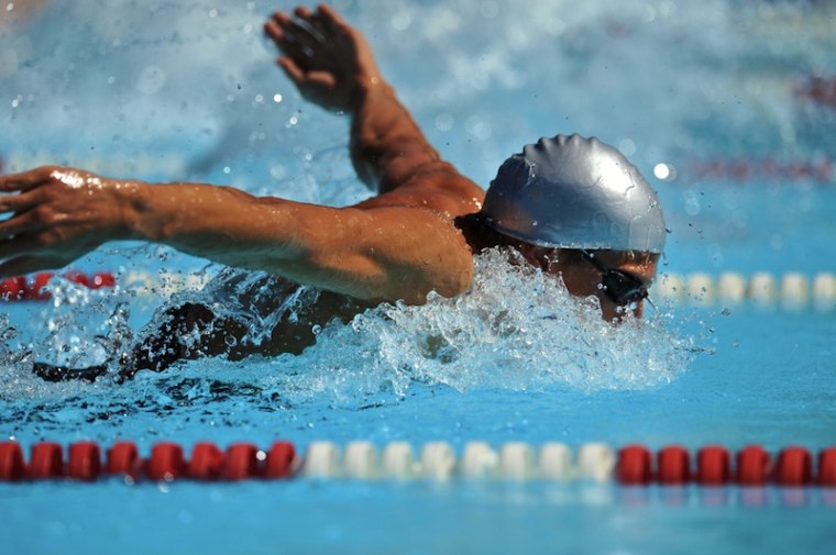 A swimmer swims the butterfly stroke.