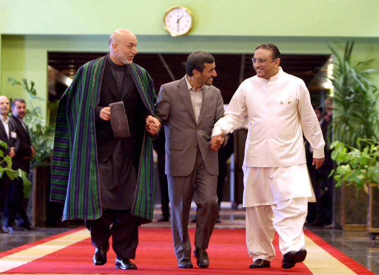 Image: Iranian President Mahmoud Ahmadinejad (C) joins hands as he arrives with his counterparts from Pakistan Asif Ali Zardari (R) and Afghanistan Hamid Karzai (L)  in Tehran