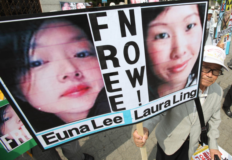 Image: A South Korean protester displays portraits of American journalists detained in North Korea