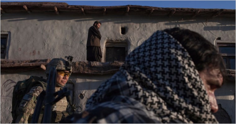 Image: A villager, right, walked home as an American soldier and an Afghan policeman, top, patrolled in Paktika Province in April