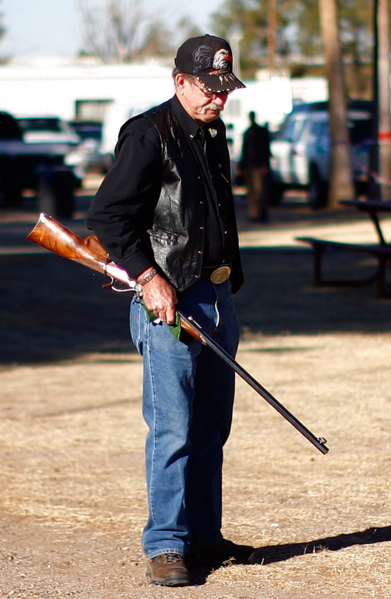 Image: A man stands outside the Crossroads of the West Gun Show at the Pima County Fairgrounds in Tucson