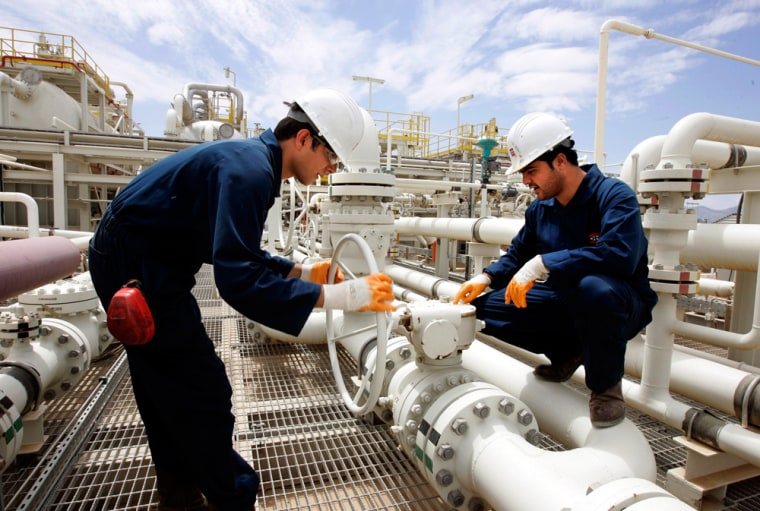 Image: Workers adjust a valve of an oil pipe in Tawke oil field near Dahuk