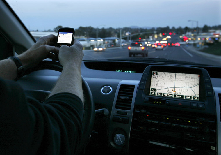 Image: A driver uses his smart phone while in traffic in Encinitas, California