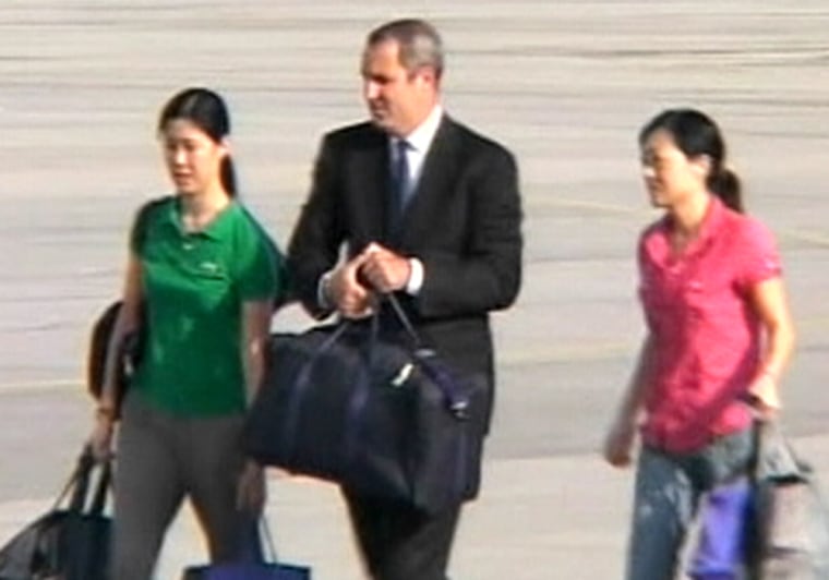 Freed American journalists Laura Ling, left, and Euna Lee, shown in a screen capture image from video with an unidentified companion, board a plane to leave North Korea on Tuesday.