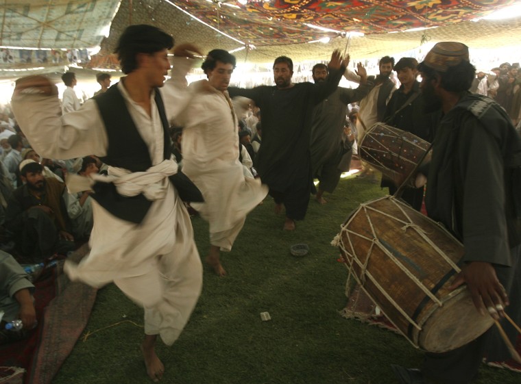 Image: Afghan men dance during an election rally in support of Afghanistan's President Hamid Karzai in Kandahar province