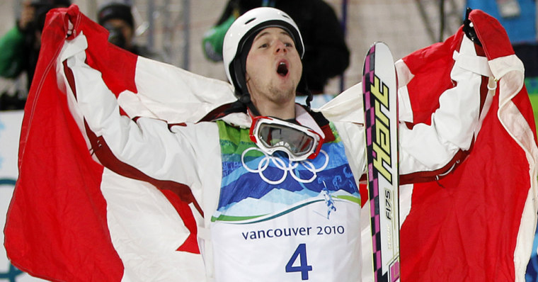 Image: Canada's Alexandre Bilodeau yells out while holding the Canadian flag after winning the gold medal during the men's freestyle skiing moguls at the Vancouver 2010 Winter Olympics
