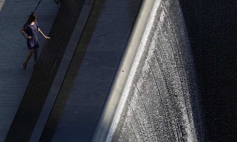 Image:A woman touches the South Pool at the  9/11 Memorial  plaza in New York