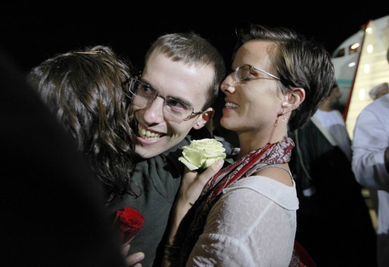 Image: Shane Bauer, one of the U.S. hikers who was held in Iran on charges of espionage, hugs fiance Sarah Shourd during his arrival in Muscat after his release from Tehran's Evin prison