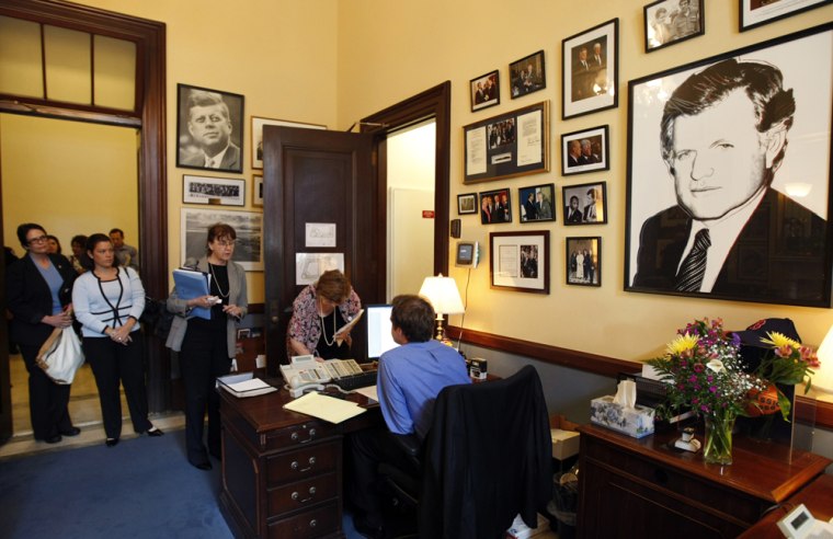 Image: People wait to sign a visitors book at Kennedy's office in DC