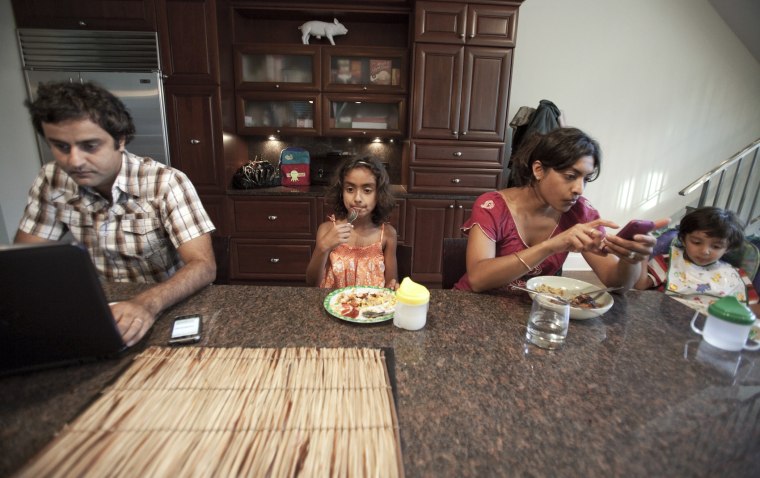 Image: From left, Rakesh Thakkar, Anika, 5, Sharmila Rao Thakkar, Shiv, 2, eat dinner in their home in Chicago.