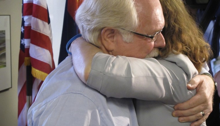Image: Ron Barber hugs a co-worker on his first day back to work