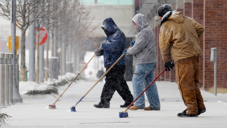 Image: Men sweeping snow