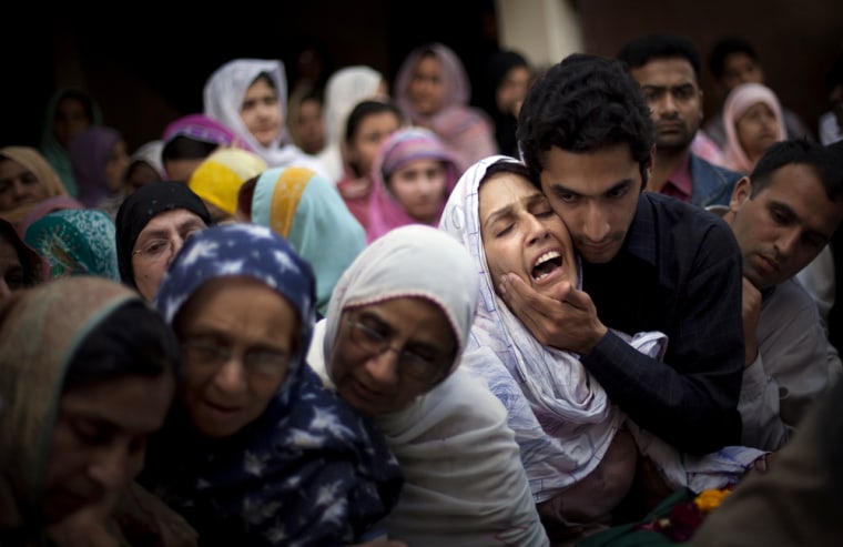 Image: Relatives of Raheel Fayz, one of the police killed on Monday's attack, react during his funeral