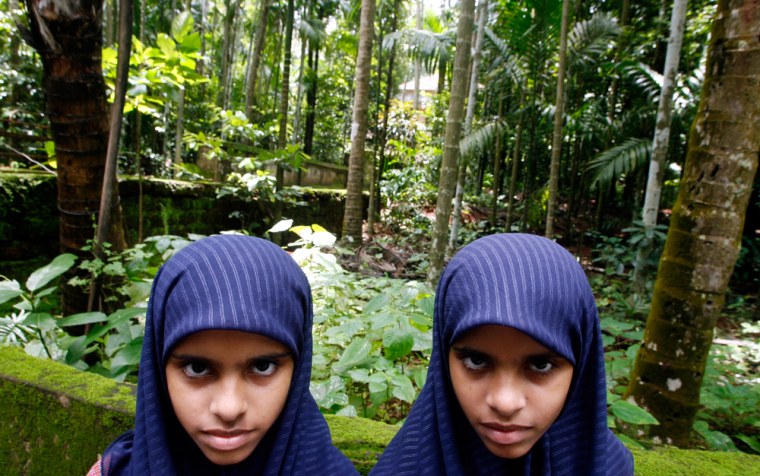 Image: Eleven-year-old twins Rasheena and Sameena pose for a photograph in Kodinji village