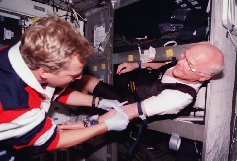 Astronaut John Glenn (right) gets bloodwork done in his bunk aboard space shuttle Discovery in 1998. About half of astronauts require sleep medication at some point during their flights, NASA said.