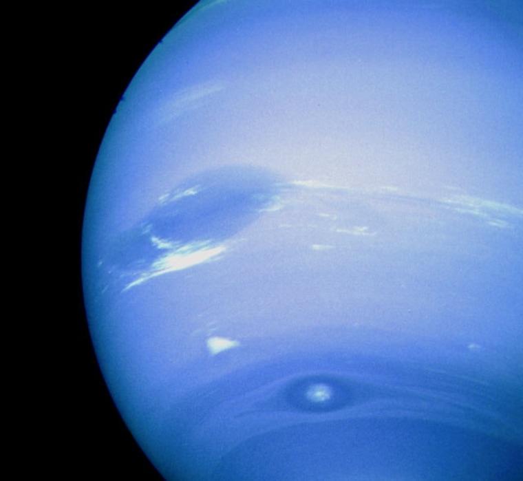 Neptune's Great Dark Spot, accompanied by white high-altitude clouds, as seen by a Voyager spacecraft.