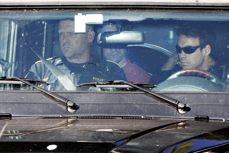 Image: Anders Behring Breivik, partially visible at center, the man who confessed to a bombing and youth camp shooting spree last Friday is transported in a police vehicle