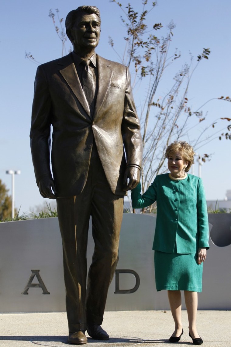Image: Elizabeth Dole, former Secretary of Transportation, holds onto a newly-unveiled statue of Reagan at Ronald Reagan National Airport near Washington