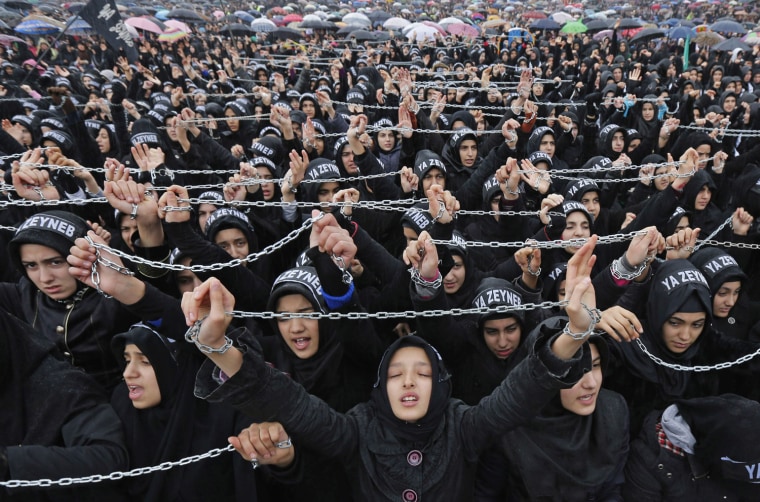 Image: Turkish Shi'ite women shout Islamic slogans as they mourn during an Ashura procession in Istanbul