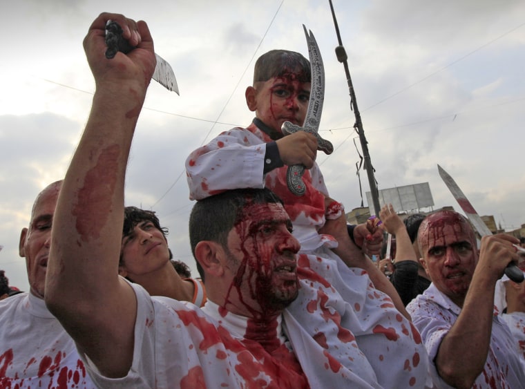 Image: Shiite Muslim worshippers, stained by their own blood from self inflicted wounds, hold knives during a procession to mark the Muslim festival of Ashura, an important period of mourning for Shiites in Baghdad