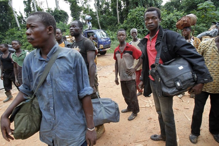 Image: Displaced cocoa farmers from the village of Baleko-Niegre stand with their belongings