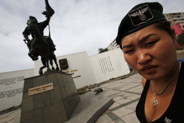 Image: Uranjargal, a leader of the Mongolian neo-Nazi group Tsagaan Khass, stands next to a statue of Chingunjav in Ulan Bator