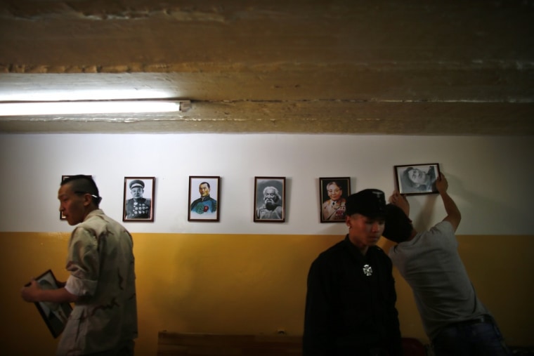 Image: Members of the Mongolian neo-Nazi group Tsagaan Khass hang up portraits of Mongolian heroes at the group's headquarters in Ulan Bator