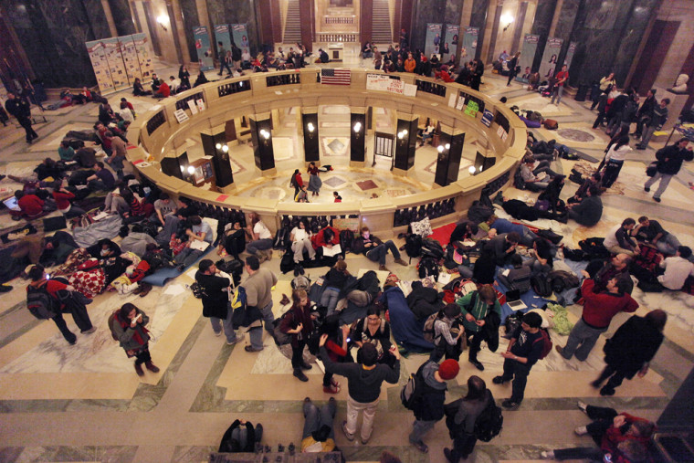 Image: People put down sleeping bags and blankets for an all-night vigil at the Capitol in Madison, Wis. near midnight
